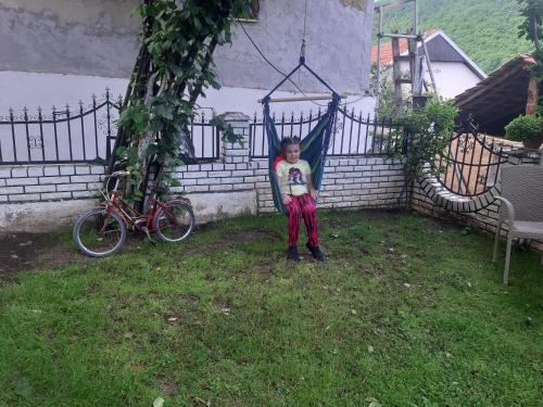 a young child sitting in a hammock in a yard at Vila Mir in Pirot