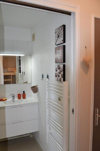 une salle de bain blanche avec un lavabo et un miroir dans l'établissement VUE MER- BEAU STUDIO - TERRASSE ABRITEE - Wi-Fi - CLIMATISATION - PARKING GRATUIT, au Lavandou