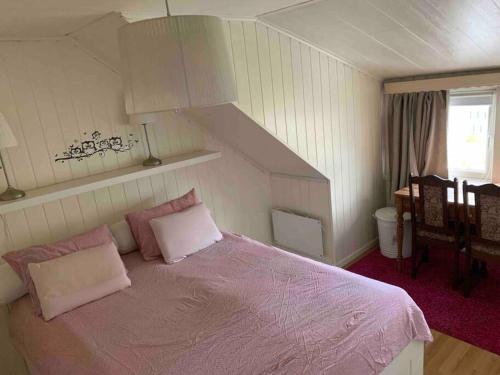 um quarto com uma cama roxa com almofadas em Dobbeltrom em Moss