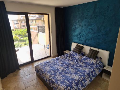 1 dormitorio con 1 cama con pared azul en Sea view apartment Kaliakria resort, en Topola