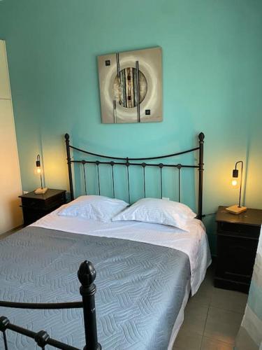 a bedroom with a bed with a blue wall at Limenari modern house in Filiatra