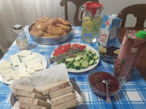 einen Tisch mit Teller mit Lebensmitteln auf einem blauen Tischtuch in der Unterkunft Albanian Traditions Legacy in Durrës