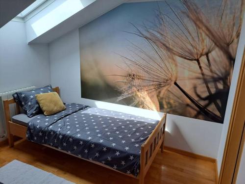 1 dormitorio con 1 cama con una pintura en la pared en Battistella's Near the Sea, en Rovinj