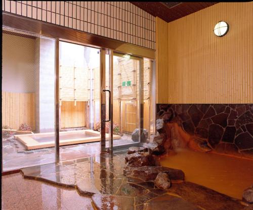 um quarto grande com uma grande janela e uma parede de pedra em Kadonobo Ryokan em Kobe