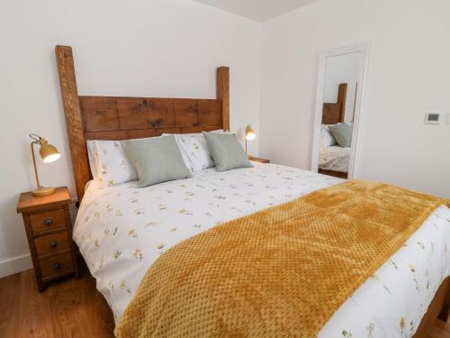 een slaapkamer met een groot bed en een spiegel bij Pear Tree Cottage in Saltash
