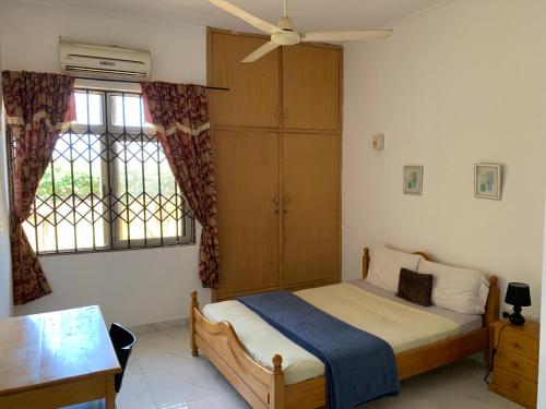 1 dormitorio con 1 cama y ventilador de techo en Accra Service Villas- 3, en Spintex