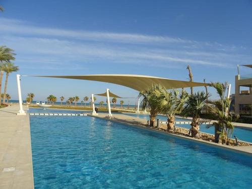 - une piscine avec un auvent sur l'eau dans l'établissement Mangroovy - Delicate 1BR Ground floor by the Pool, à Hurghada