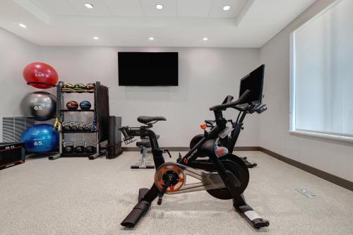 a room with a gym with a bike and a flat screen tv at Home2 Suites By Hilton Petaluma in Petaluma