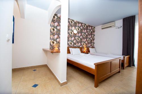 a bedroom with a bed with a floral wall at Tanja Apartments in Rafailovici