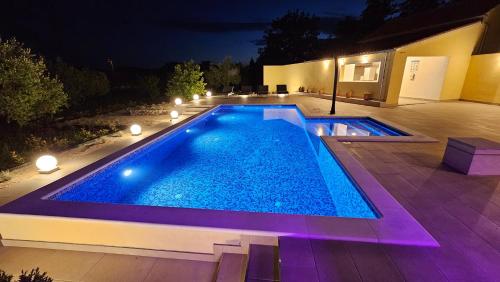 a swimming pool in a backyard at night at Villa Umbra et Sol in Gruda