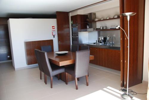 a dining room with a table and chairs and a kitchen at Apartamento T1 Herdade dos Salgados in Albufeira