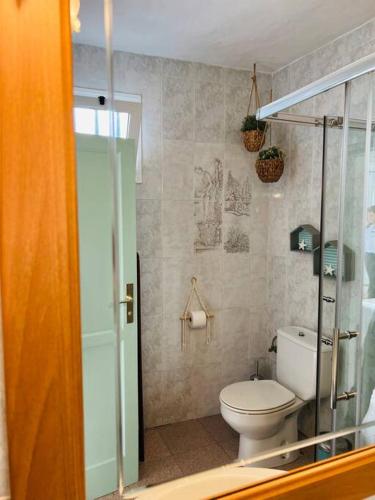 a bathroom with a toilet and a glass shower at Blue relax house in Punta Mujeres