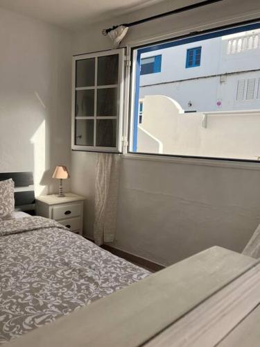 a bedroom with a bed and a window at Blue relax house in Punta Mujeres