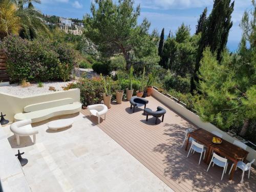 a patio with a couch and chairs and tables at EXQUISITE GOLF VILLA with Sea, 8Tee, Green Views, in Aphrodite Hills Golf Resort in Kouklia