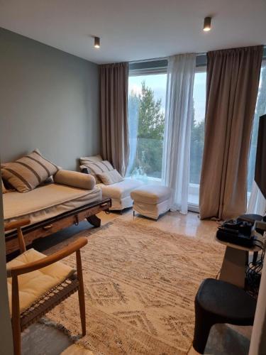 a living room with a couch and a large window at EXQUISITE GOLF VILLA with Sea, 8Tee, Green Views, in Aphrodite Hills Golf Resort in Kouklia