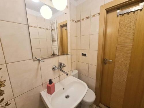 een badkamer met een wastafel, een toilet en een spiegel bij MirrorRoom PL CityCenter in Warschau