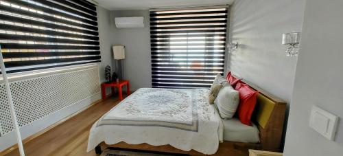 a bedroom with a bed with pillows and a window at Amazing Seaview Flat in Kuşadası