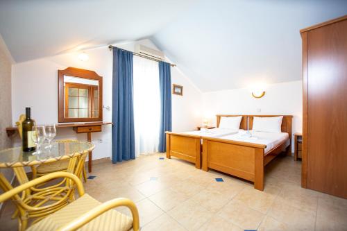 une chambre d'hôtel avec un lit, une table et des chaises dans l'établissement Tanja Apartments, à Rafailovici