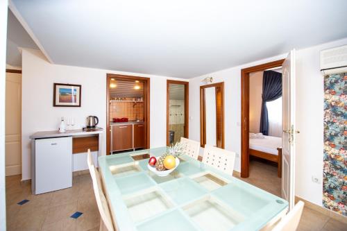 a kitchen and dining room with a glass table at Tanja Apartments in Rafailovici