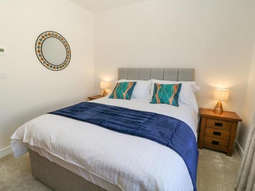 Un dormitorio con una cama grande con un espejo en la pared. en Meadow Bay, en Bideford