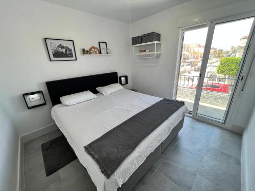 ein Schlafzimmer mit einem großen Bett und einem großen Fenster in der Unterkunft Prachtig gemoderniseerde woning op 250 meter van het strand in Santa Pola