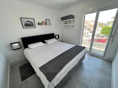 a bedroom with a large bed with a large window at Prachtig gemoderniseerde woning op 250 meter van het strand in Santa Pola