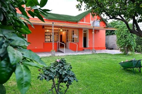 una casa roja con una carretilla delante en Sayani Posada in 