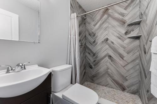 a bathroom with a toilet and a sink and a shower at Harbor Light Family Resort in North Wildwood