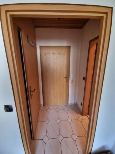 a hallway with a door and a tiled floor at Maria Apartment in Wolfsburg