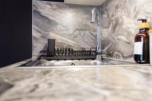 a kitchen sink with a bottle of wine next to it at Stylish Retreat in Hove