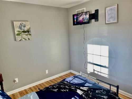 ein Schlafzimmer mit einem Bett und einem TV an der Wand in der Unterkunft Reed Legacy, LLC Home in Newark