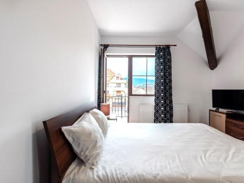 a bedroom with a bed and a large window at Apartamente Simona Brasov in Braşov