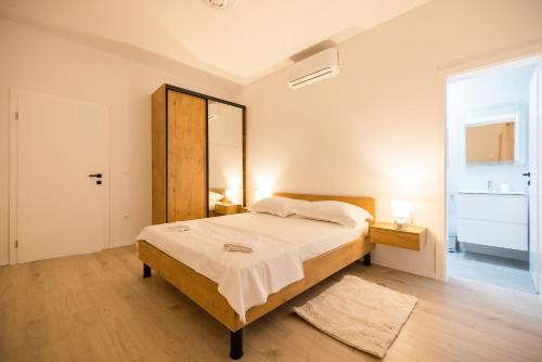 a bedroom with a large bed and a mirror at Villa Matea in Nin