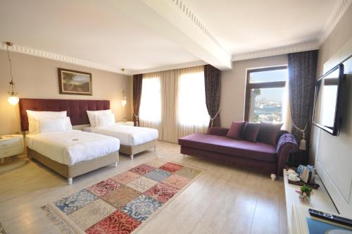una camera d'albergo con due letti e un divano di Nea Suites Old City a Istanbul