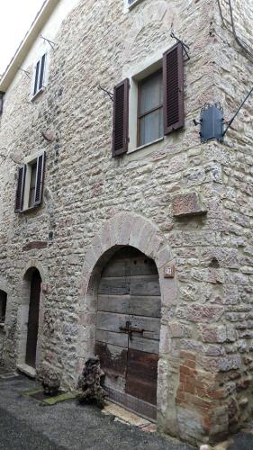 ein altes Steingebäude mit einer Tür und einem Fenster in der Unterkunft Casa Momo in Montecchio