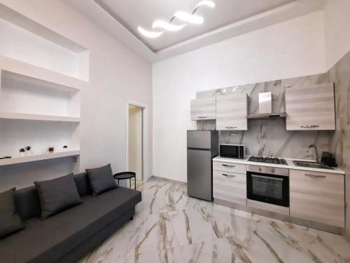 Il comprend un salon avec un canapé et une cuisine. dans l'établissement Re Ferdinando Apartment, à Naples