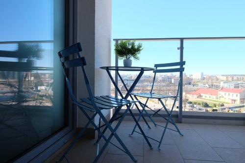 two chairs and a table in front of a window at Apartamenty Centrum in Białystok