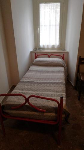 two beds in a small room with a window at Casa Momo in Montecchio