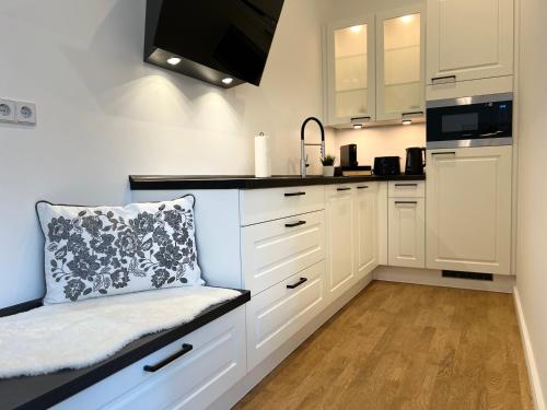 a kitchen with white cabinets and a pillow on a counter at Goethe Palais Suite Charlotte 4P l Lift I ParkplatzI Zentrum I Helios in Aue
