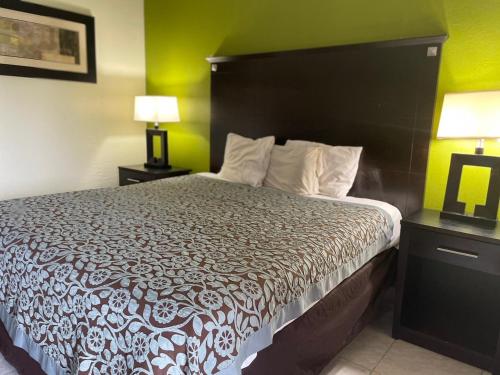 a bedroom with a large bed with a black headboard at Regency Inn in Perry