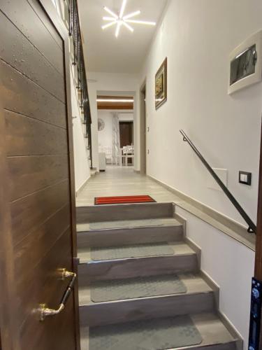 a hallway with stairs with a door and a red rug at B&B al Vicoletto in Bellante
