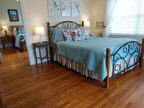 a bedroom with a bed and a wooden floor at Urban Cottages in Little Rock