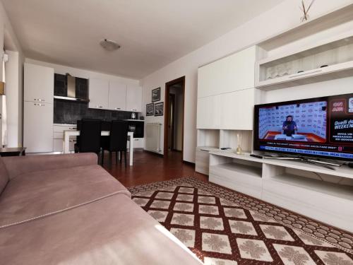 a living room with a couch and a tv on a wall at Appartamento Gelsomino in Riva di Solto