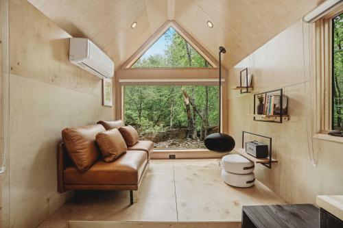 - un salon avec un canapé et une grande fenêtre dans l'établissement Lumen Nature Retreat, à Woodstock