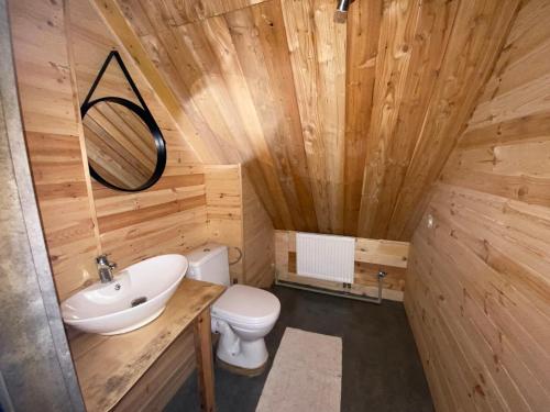 a wooden bathroom with a toilet and a sink at Agroturystyka u Moniki in Masłów