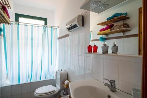 baño con aseo y lavabo y ventana en Villa Etna Pippo, en Piedimonte Etneo