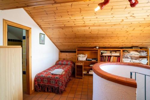 ピエディモンテ・エトネーオにあるVilla Etna Pippoのベッド1台とバスタブ付きの客室です。