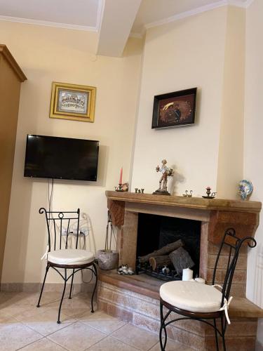 a living room with two chairs and a fireplace at Pyrgos in Pyrgi