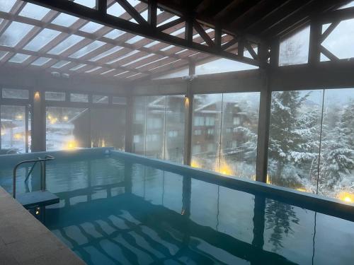 una piscina con vista a una montaña nevada en Las Aguas Río Bonito, en Villa La Angostura