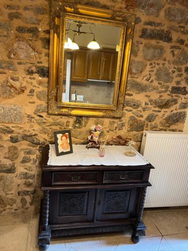 a bathroom sink with a mirror on a stone wall at Pyrgos in Pyrgi